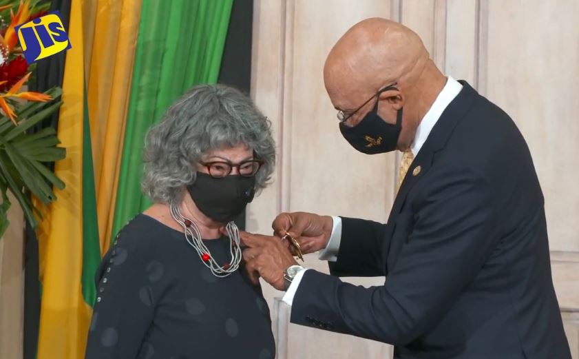 Olive Senior, Jamaica's Poet Laureate 2021-2024 is pinned by Governor-General of Jamaica, His Excellency the Most Hon. Sir Patrick Allen during her Ceremony of Investiture at King's House, Kingston on Wednesday, March 17, 2021. Screenshot from https://www.facebook.com/JISVoice/videos/191160926100520