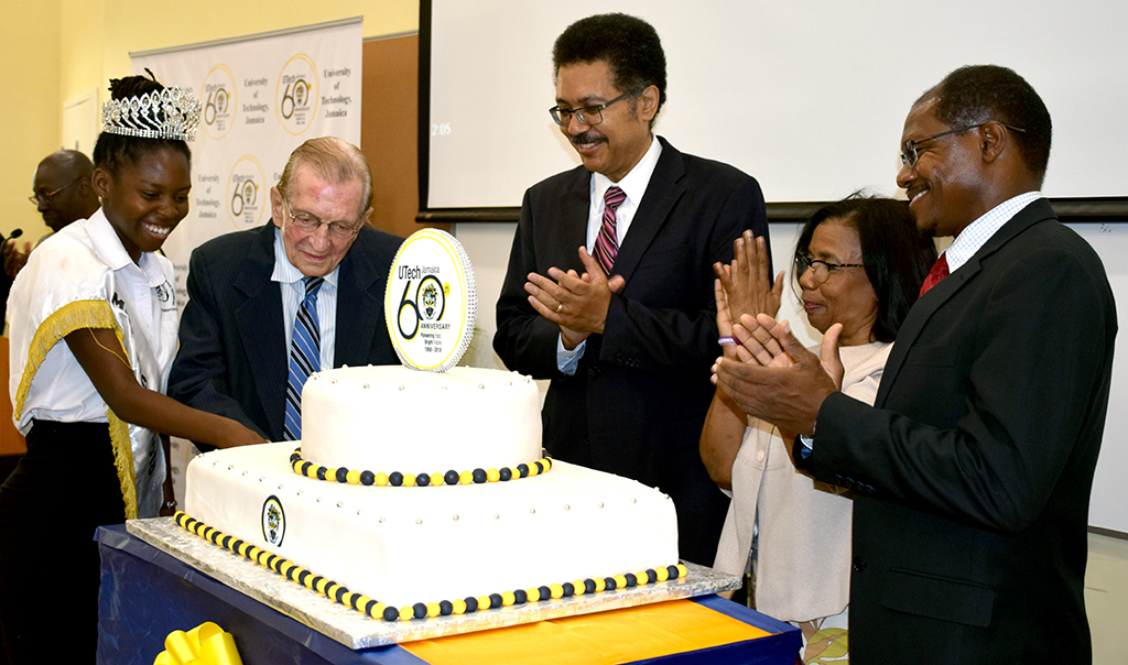 Professor Collin Gyles, Deputy President, University of Technology, Jamaica (UTech, Ja.) (right) and Professor Stephen Vasciannie, CD, President, UTech, Ja. Applaud as The Most Honorable Edward P.G. Seaga, University’s Chancellor (2nd left) cuts the 60th cake with Ms. Alecia Bailey, Miss University of Technology, Jamaica 2018 (left) at the ceremony of University’s 60th anniversary launch, March 20, 2018. Photograph by UJS News/Chenea Taffe
