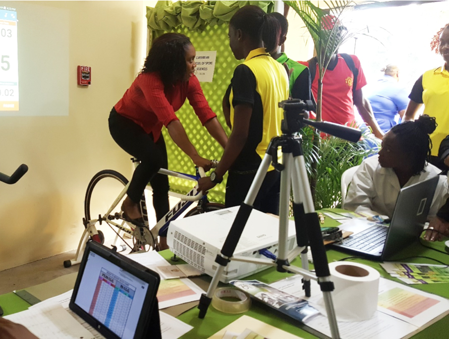 Ashleigh Williams a student of the Faculty of Sport & Science demonstrates to a participant how to monitor her active heart rate at UTech, Ja Research Day on March 08, 2018.