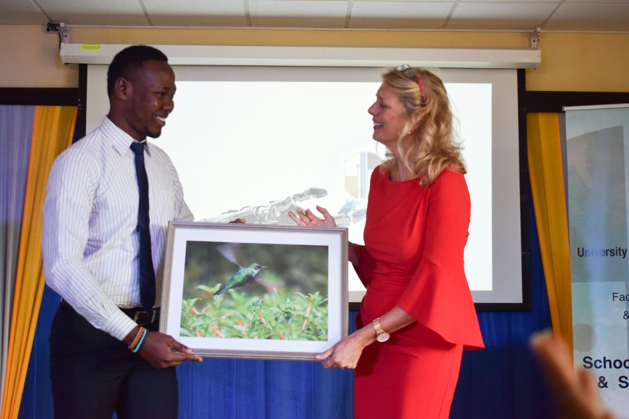 Picture 4: Guest speaker, Canadian High Commissioner to Jamaica, Laurie Peters, receives a gift from Chevauni Blair, a final year student of the University of Technology Jamaica at the launch of the final year student exhibition of the BA Communication Arts and Technology programme at the Papine campus of the University of Technology, Jamaica on May 3 2018.