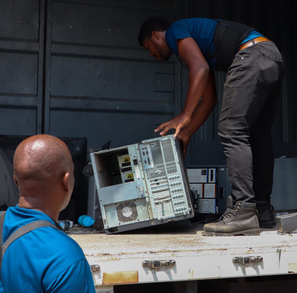 Workmen from the National Solid Waste Management Authority load a CPU into an e-waste truck at Campion College on Friday, March 22, 2024. Photo by Ardrene Edwards